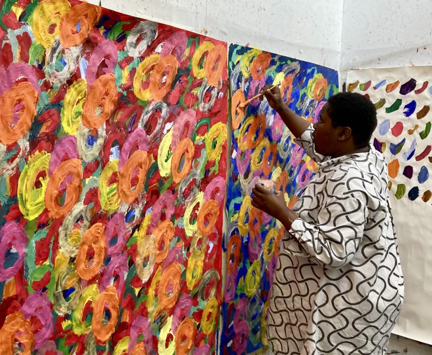 Photo of artist Kwaga Sillingi painting a large scale painting in the ActionSpace studio