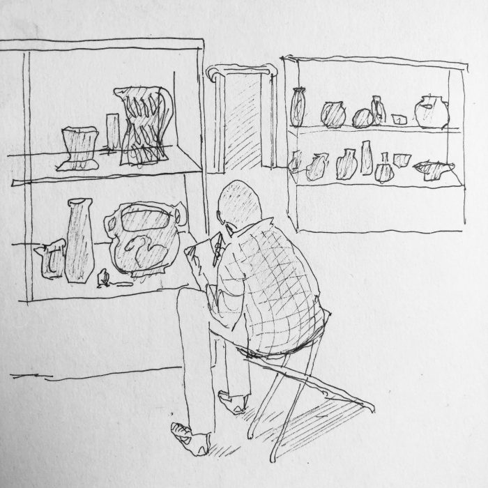 Drawing in pencil of Adam drawing artefacts in glass display units at the British Museum