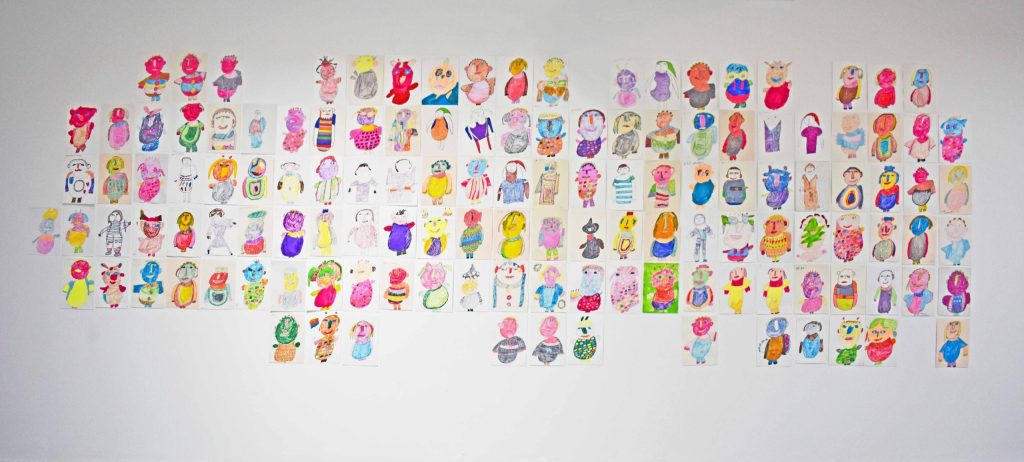 White wall covered in dozens of A4 colourful illustrations of portraits and characters