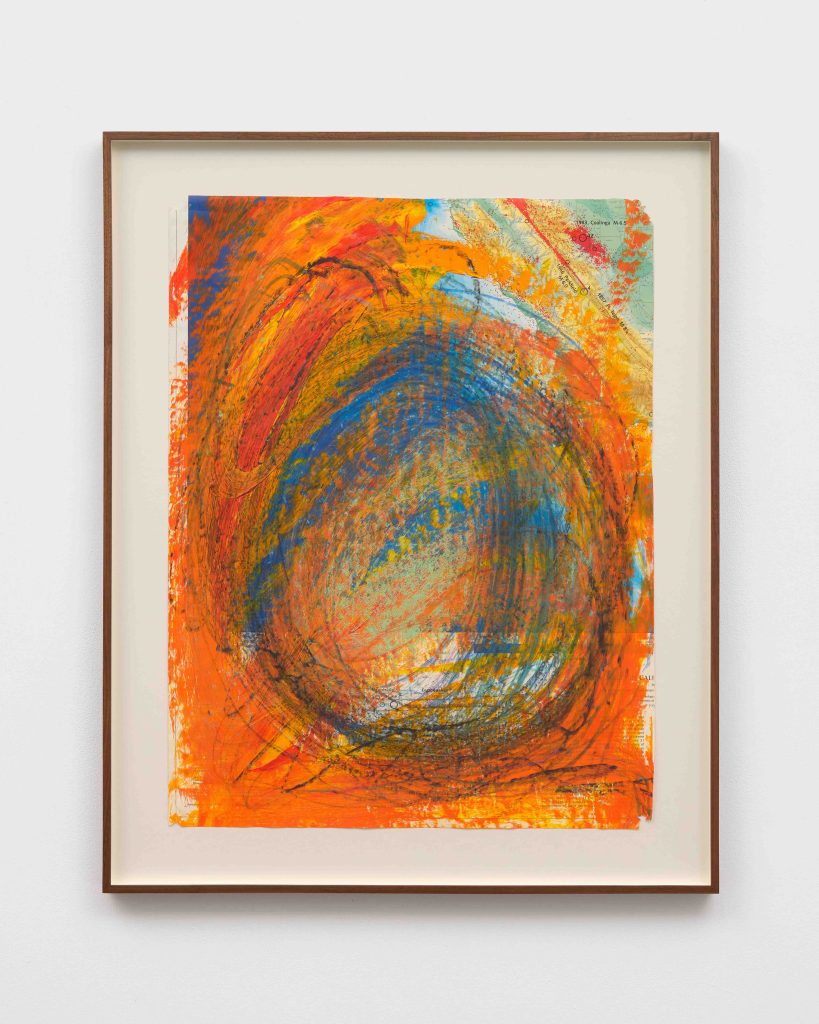 A framed drawing in orange and blue swirls of acrylic and oil pastel on a paper map.